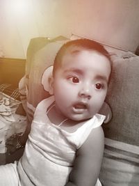 Portrait of cute baby relaxing on bed at home