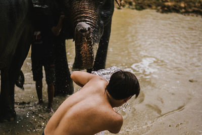 Midsection of shirtless man in water