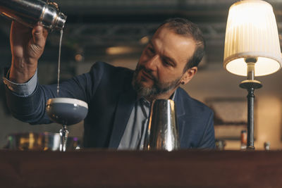 Male bartender preparing cocktail at bar counter