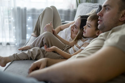 Father and mother watching tv with son at home