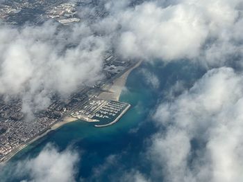 Low angle view of cityscape against cloudy sky