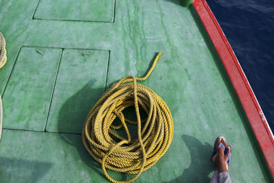 Low section of person by ropes on boat deck