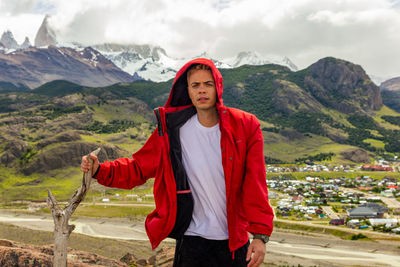 Portrait of man standing on mountain against sky