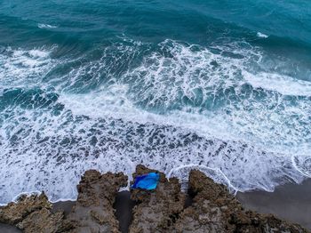 High angle view of waves splashing on rocks