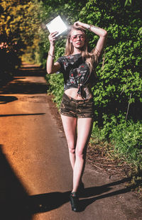 Full length portrait of young woman using mobile phone