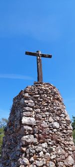 Low angle view of cross against clear blue sky