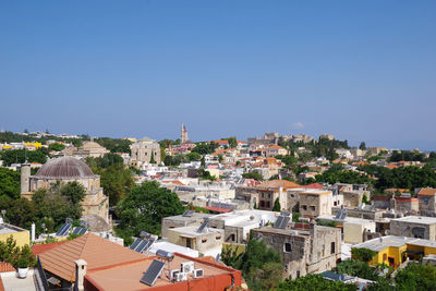 Buildings in city against clear sky