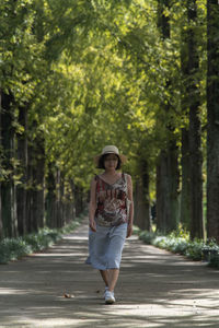 Full length portrait of woman standing on footpath