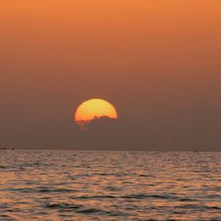 Scenic view of sea against orange sky