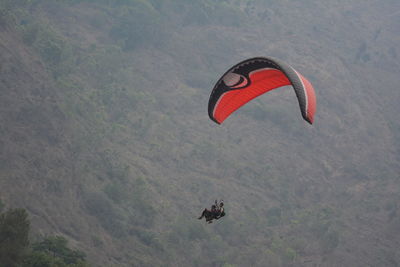 Person paragliding over mountain