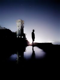 Silhouette man standing against clear sky at night