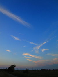 Scenic view of silhouette field against sky at sunset