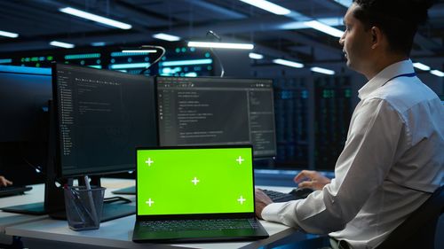 Rear view of man using laptop at office