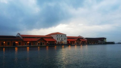 Houses by sea against sky