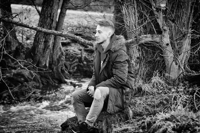 Young man looking away in forest