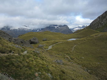 Scenic view of mountains against cloudy sky