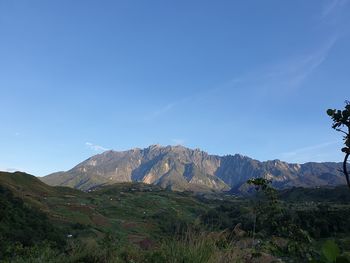 Scenic view of mountains against blue sky