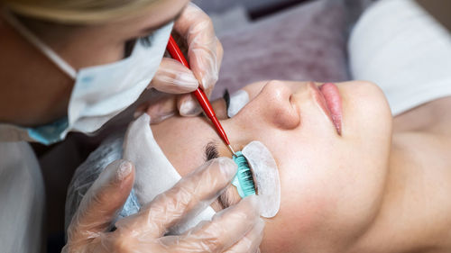 Midsection of woman applying nail