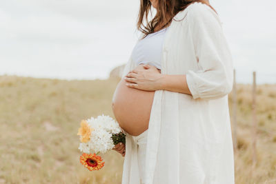 Midsection of woman holding flowers