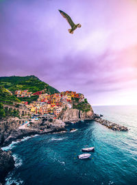 Buildings by sea on mountain at manarola 