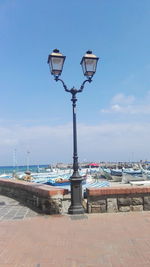 Street light by sea against sky