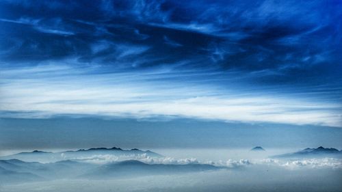 Scenic view of mountains against cloudy sky