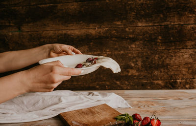 Cropped hands of woman holding coffee on table