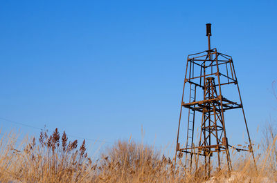 Low angle view of communications tower against clear blue sky