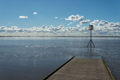 Pier on lake against sky