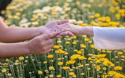 The man wears a wedding ring on woman's hand