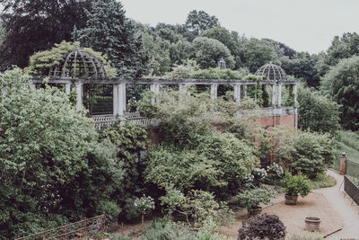 Built structure by trees against sky