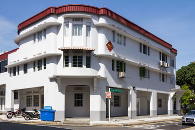 Residential building by street against sky