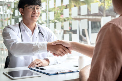 Midsection of doctor working at office