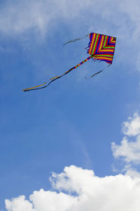 Low angle view of kite flying against blue sky