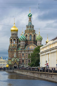 View of buildings in city against cloudy sky