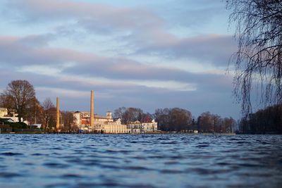 Scenic view of lake by city against sky