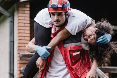 Paramedic worker rescuing woman during disaster