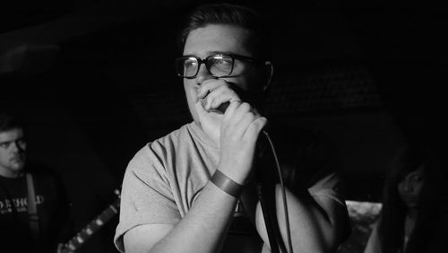 Musician looking away while singing at recording studio