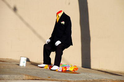 Magician sitting against wall