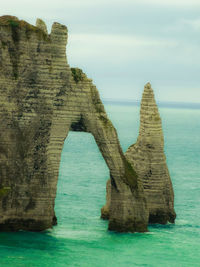 Rock formation in sea against sky