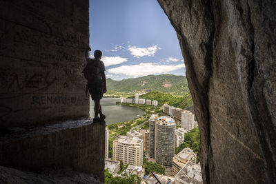 View to rock climbing man on mountain edge with concrete support pilar