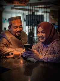 Young woman using mobile phone while sitting at home