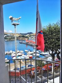 Boats moored at harbor against clear blue sky