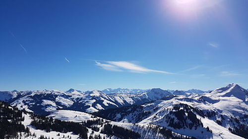 Scenic view of snowcapped mountains against blue sky