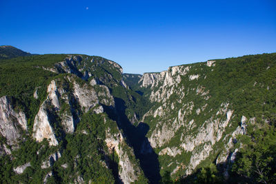 Scenic view of rocky mountains against clear blue sky