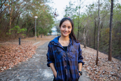 Portrait of smiling young woman standing on land