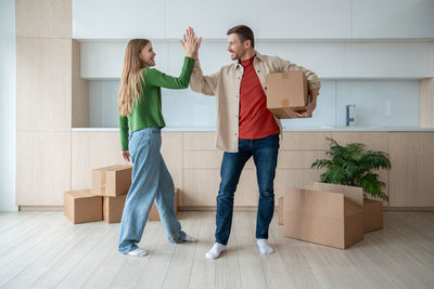 Full length of couple standing against wall