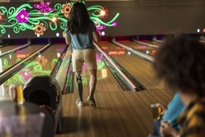 Man with artificial limb playing at bowling alley