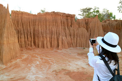 Rear view of woman standing against the sky