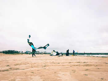 People at beach against sky